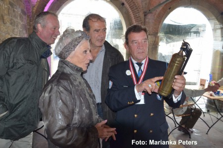 Deelnemer met historische jeep krijgt een originele brandblusser uit 1942 overhandigd door Richard Marchand